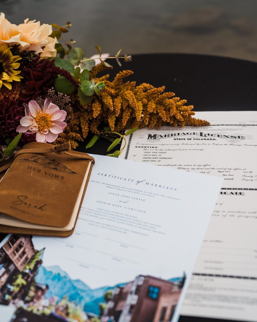 Colorado marriage certificate with leather vow books and flowers