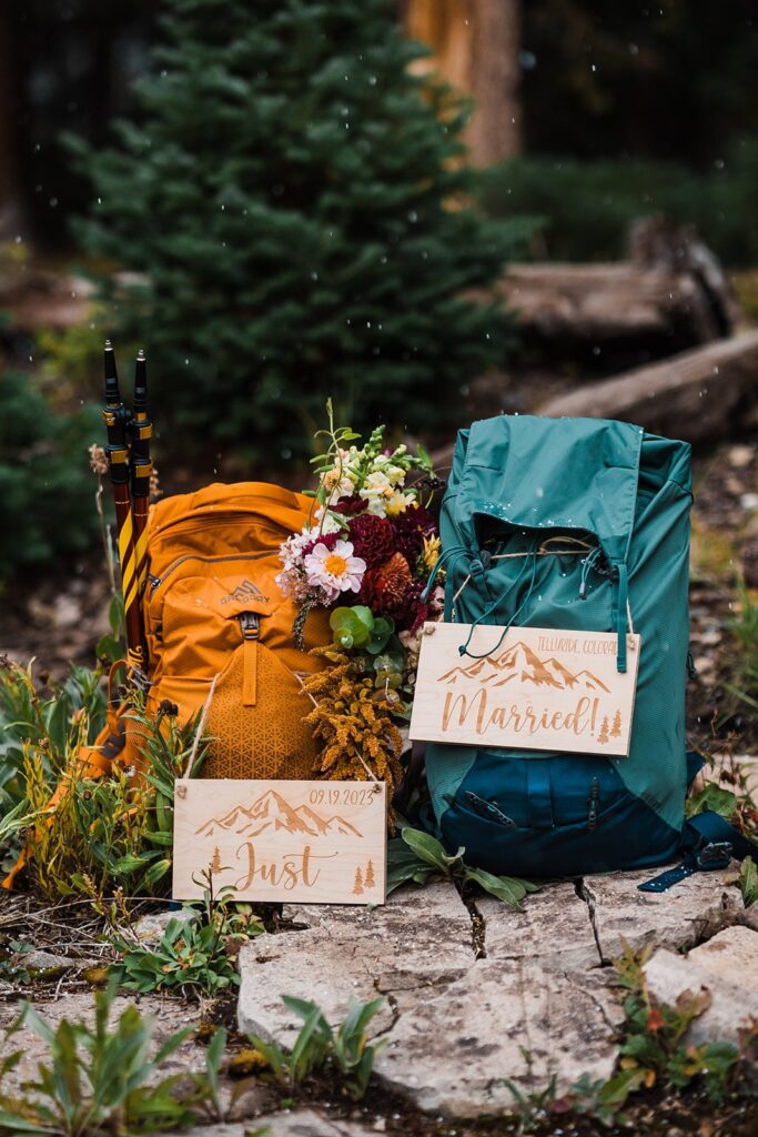 Blue and orange hiking backpacks with wood "Just Married" signs attached