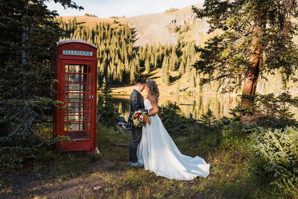 Telluride elopement photos by a red telephone booth at an alpine lake