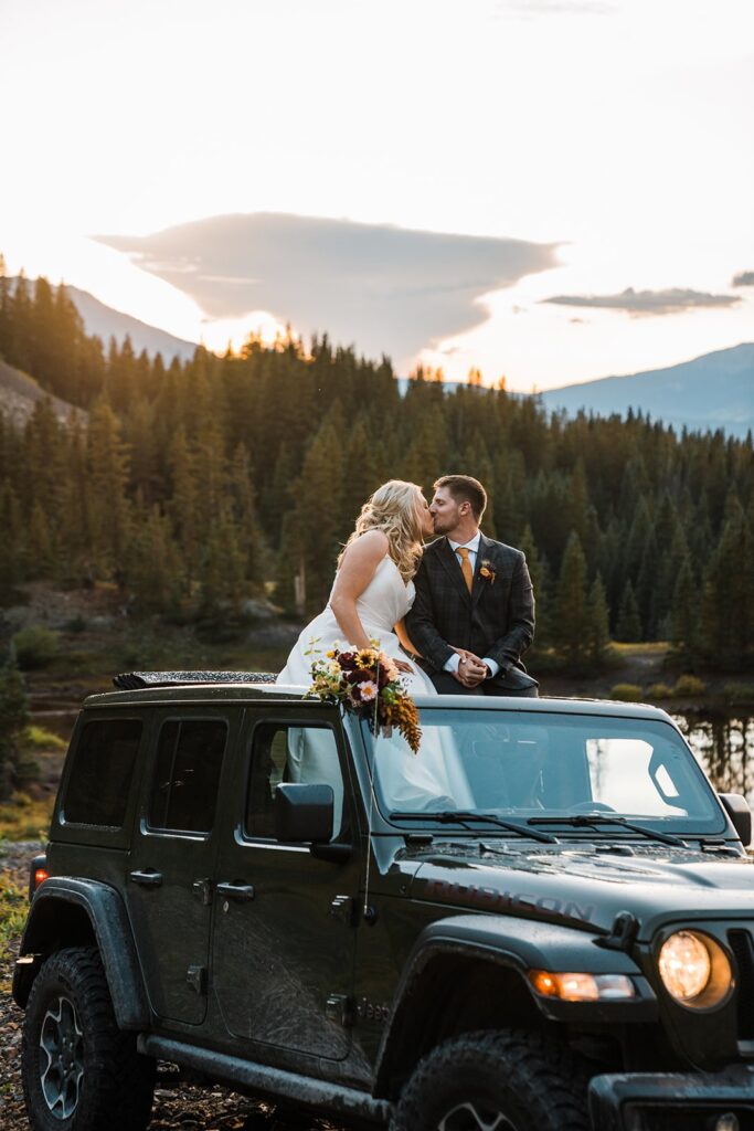 Bride and groom kiss in their black Jeep during sunset at their Telluride elopement