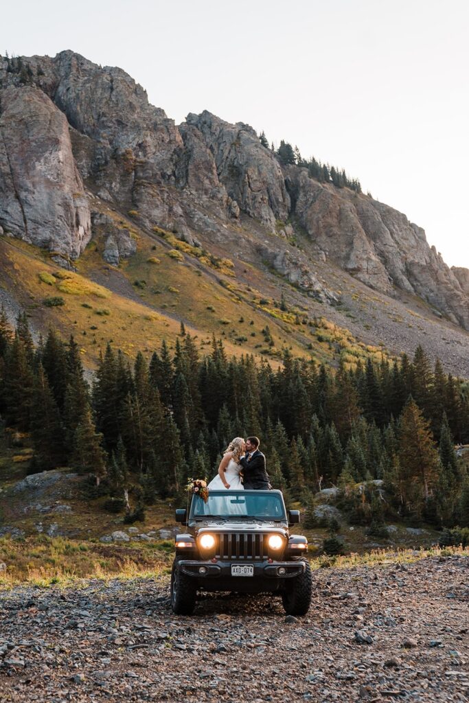 Bride and groom kiss in their black Jeep during sunset at their Telluride elopement