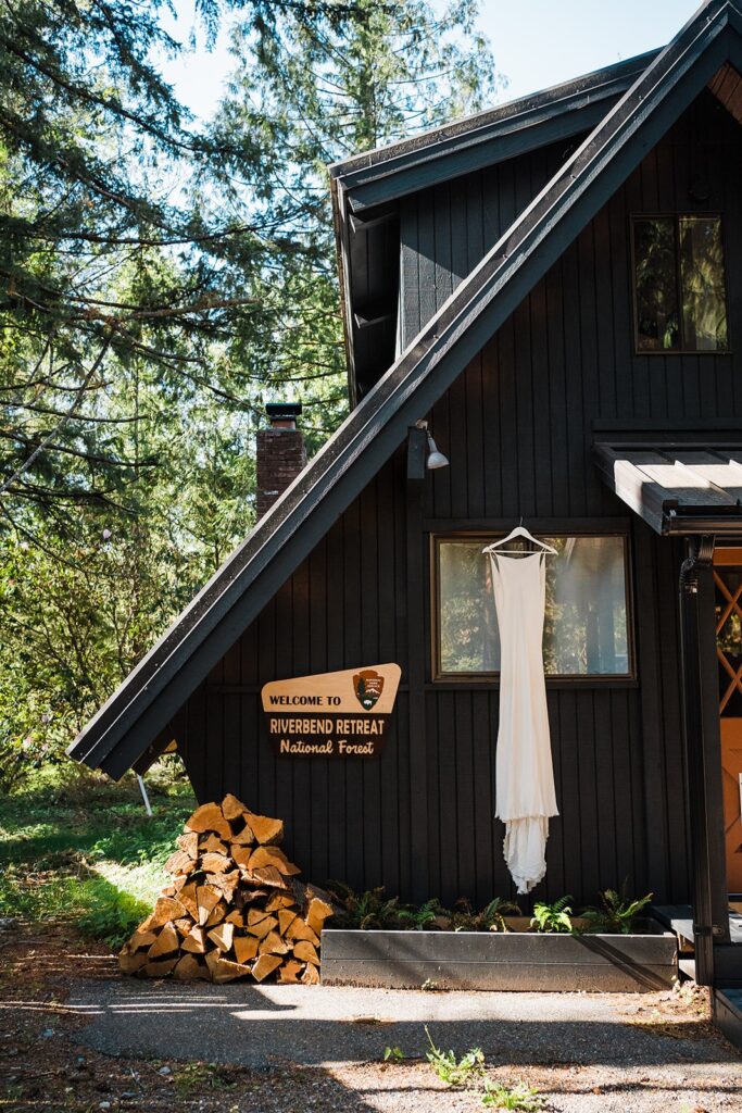 The Riverbend Retreat cabin with a white wedding dress hanging from the window