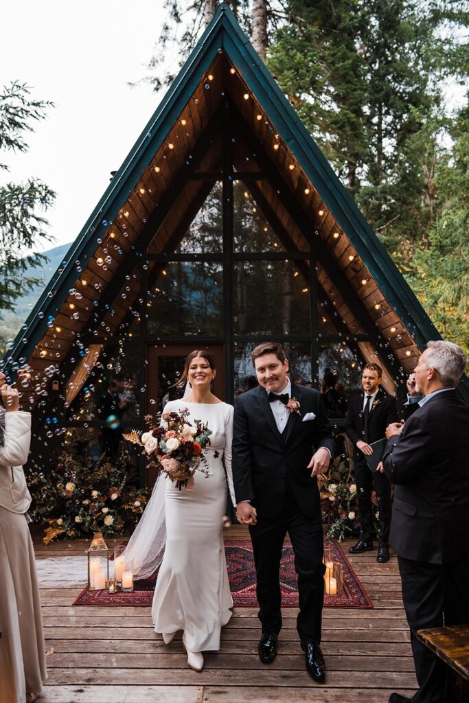 Bride and groom exit their Airbnb wedding ceremony at an A-frame cabin in Washington