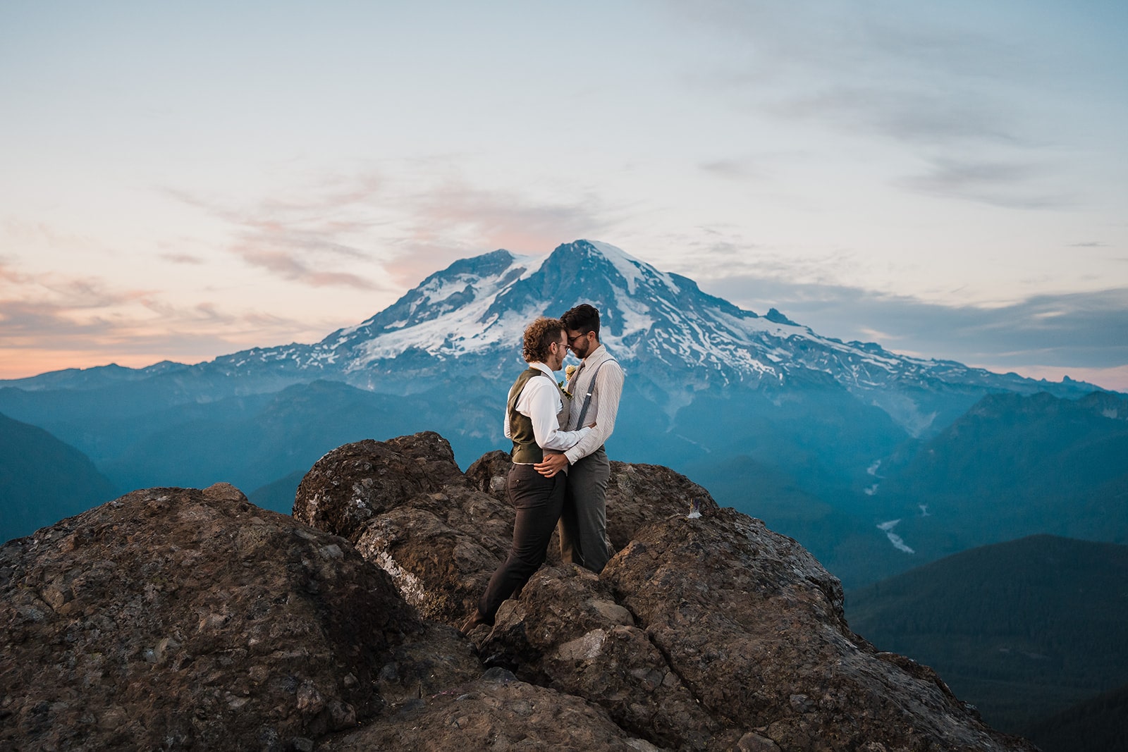 Grooms hug on a mountain trail during their elopement in Washington state