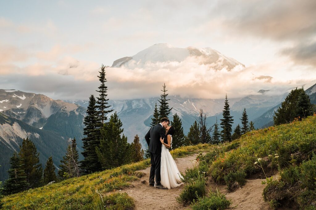 Bride and groom kiss on a trail at their Mt Rainier elopement