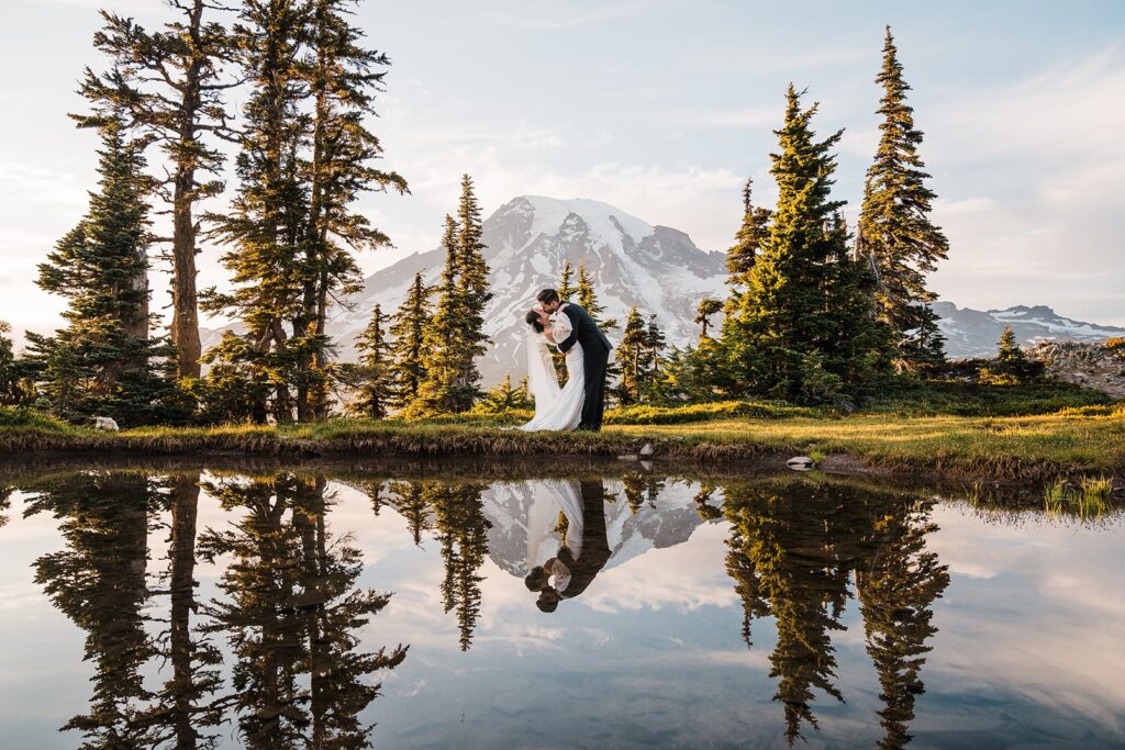 Groom dips bride for a kiss by an alpine lake while they elope in Washington