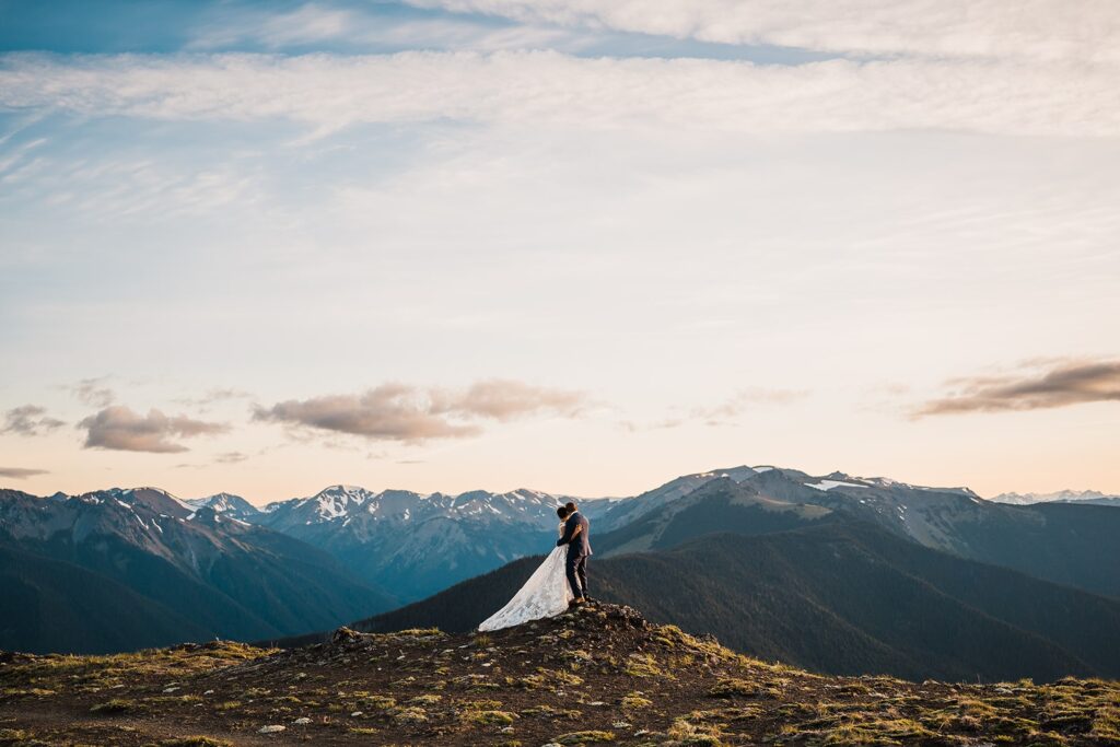 Bride and groom hug and look out at at the mountains during their Olympic National Park elopement
