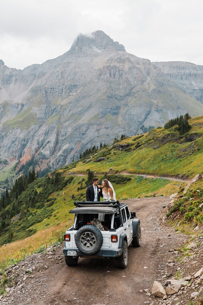 Bride and groom sit in a jeep during their off-roading elopement at Rocky Mountain National Park