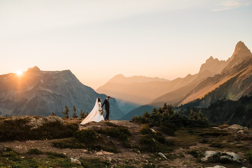 Bride and groom hold hands as they walk through the mountain at their North Cascades wedding
