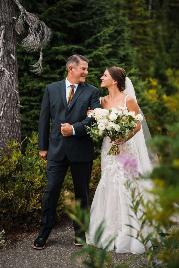 Father and bride walk down the aisle during their Washington micro wedding ceremony in the North Cascades