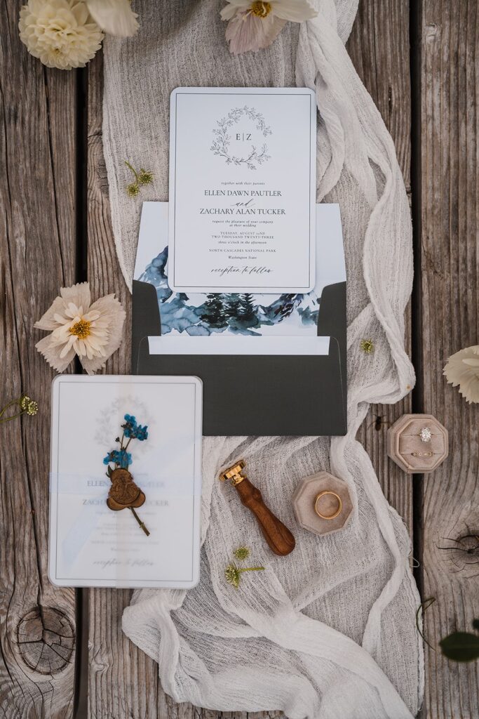 White and blue wedding stationary lying on a picnic table 