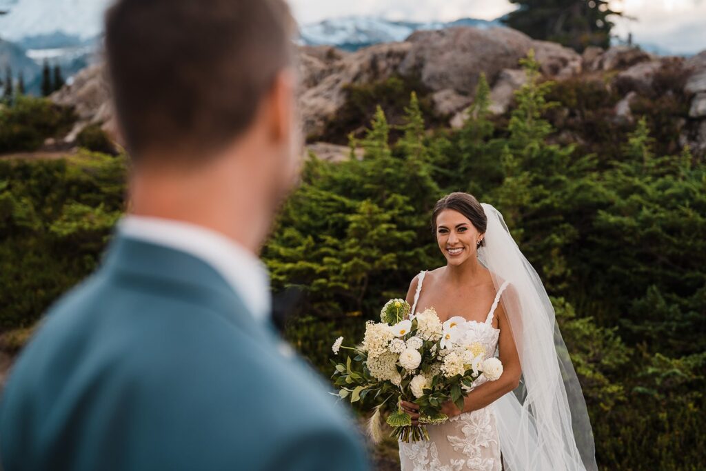 Bride smiles at groom during their wedding photos in the North Cascades