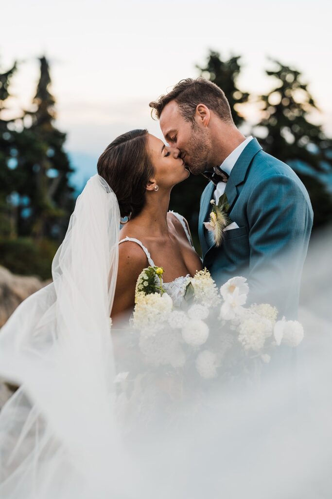Bride and groom kiss during their sunset wedding photos in the North Cascades