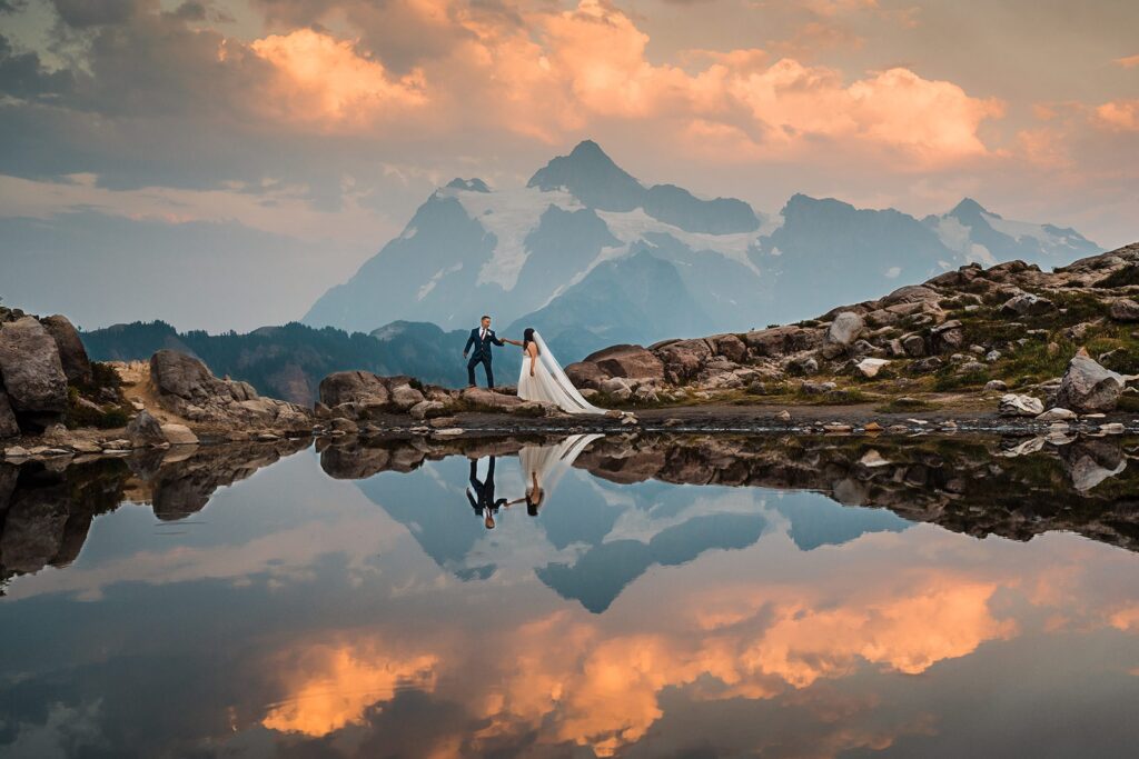 Bride and groom hold hands as they walk around Artist Point during their elopement