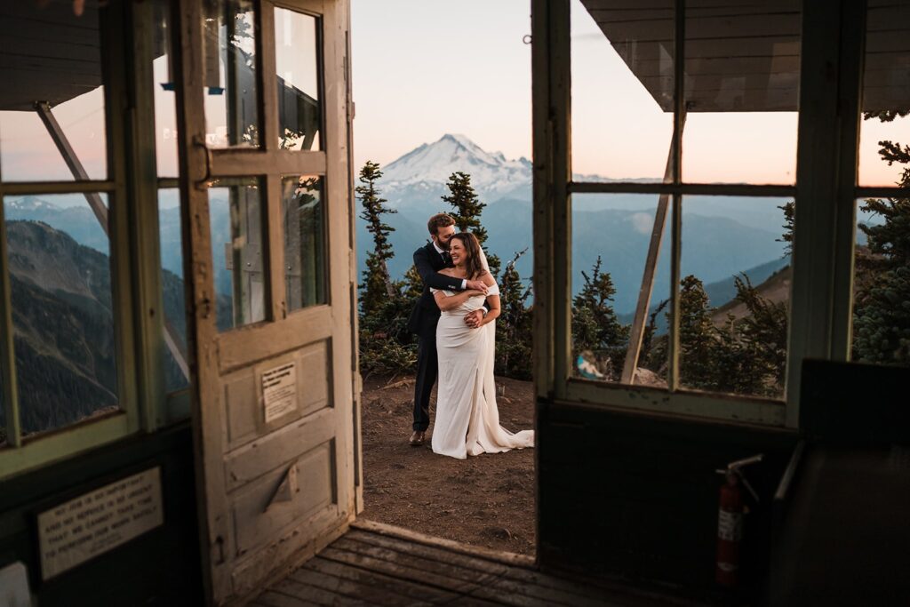 Bride and groom hug at a fire lookout at their North Cascades elopement