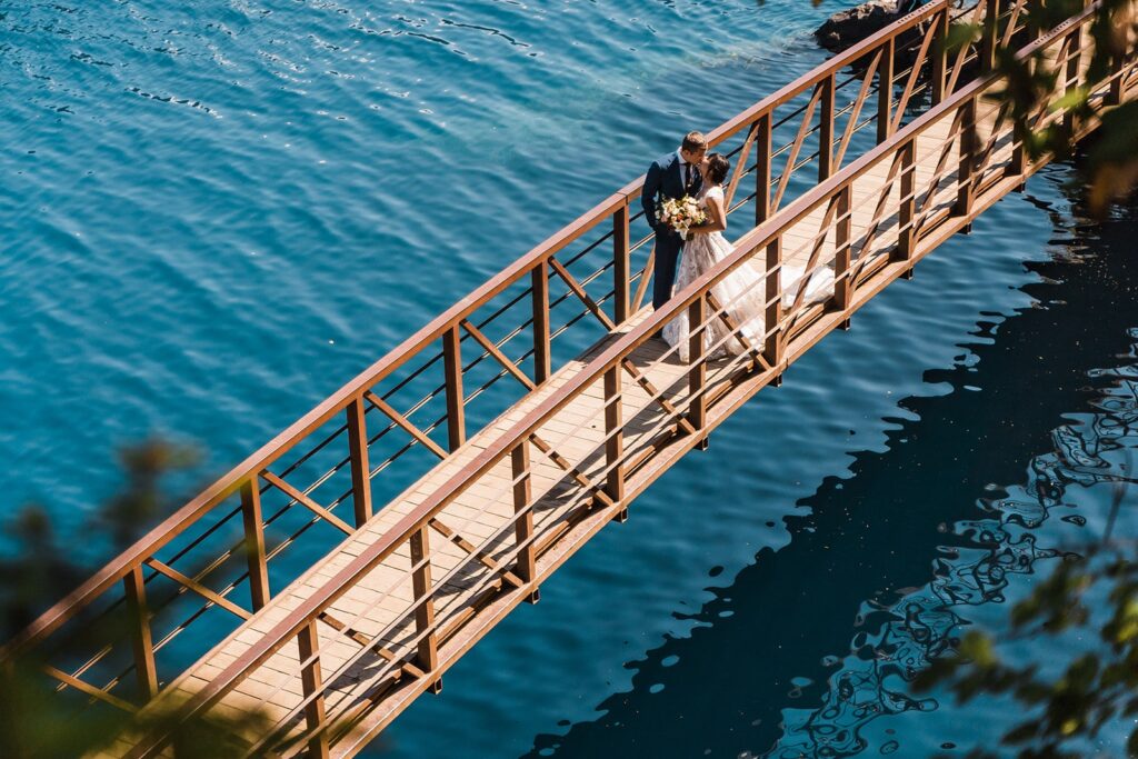 Bride and groom kiss on a wood bridge during their Olympic National Park elopement