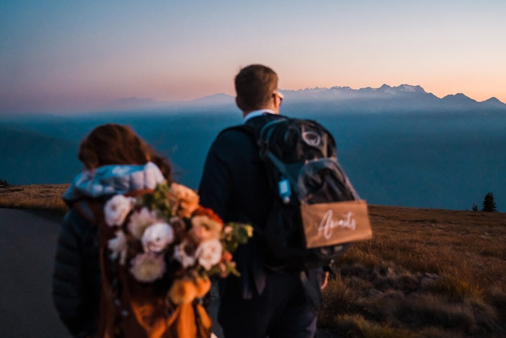 Bride and groom hike down the mountain with their backpacks after their Olympic National Park elopement