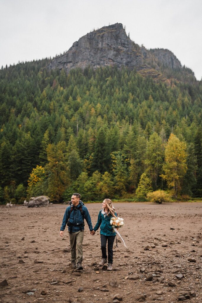 Bride and groom hold hands while hiking to their Pacific Northwest elopement in Snoqualmie
