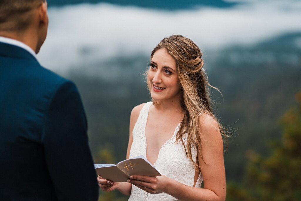 Bride looks up at groom while reading private vows during their Snoqualmie elopement