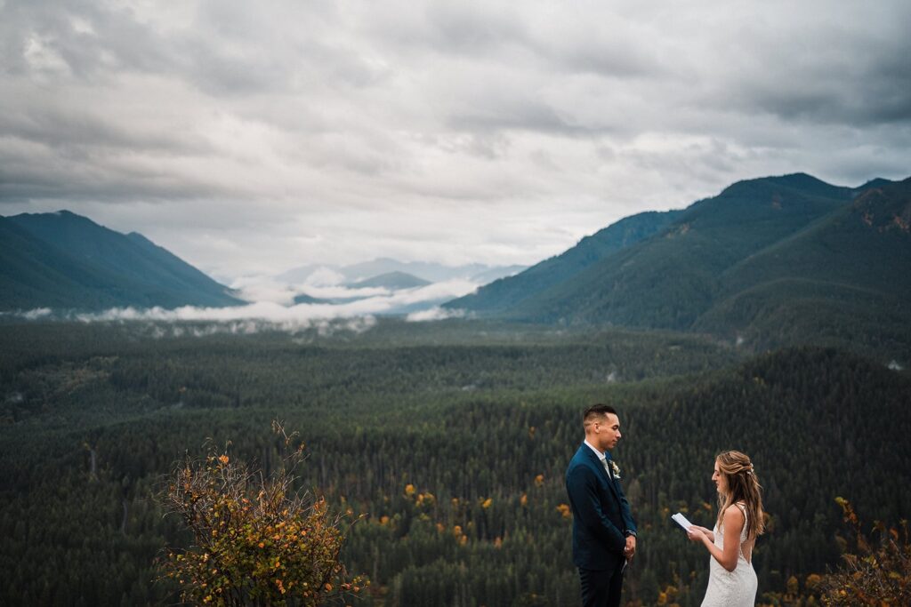 Bride reads vows to groom during their foggy Pacific Northwest elopement in Snoqualmie