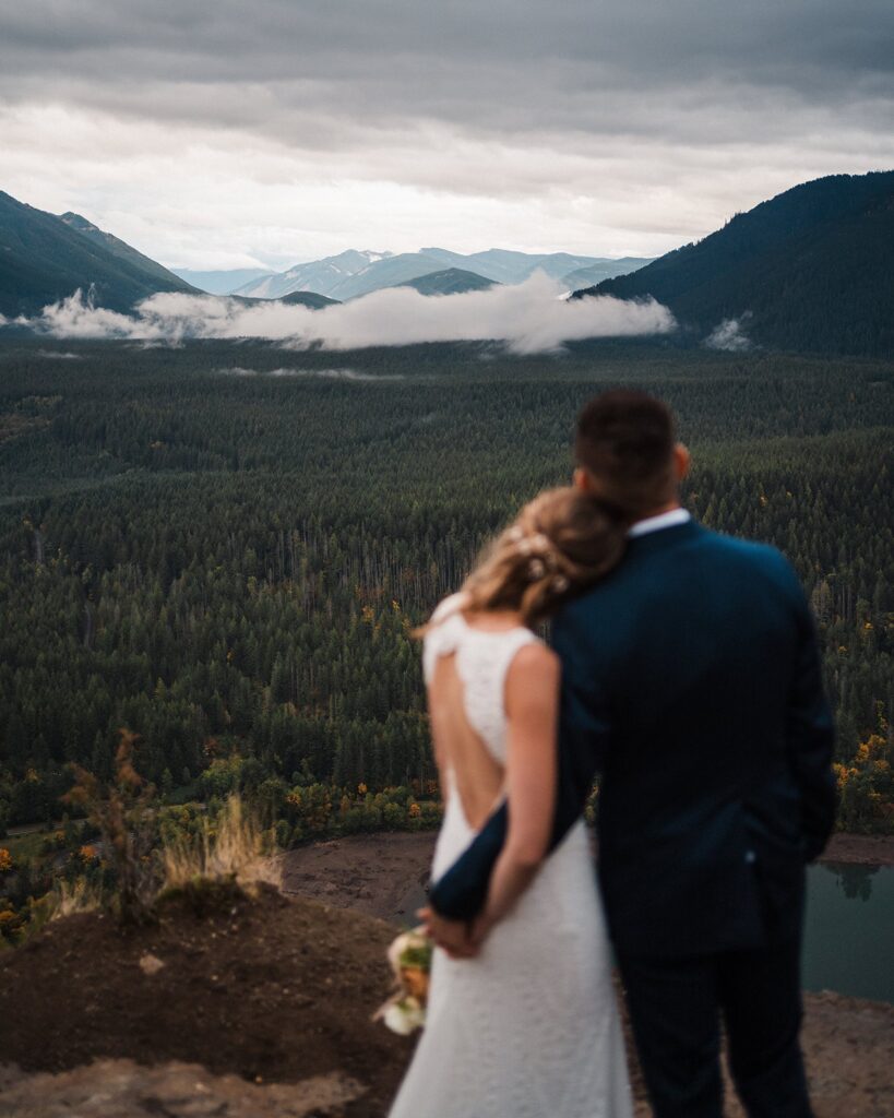 Bride and groom look out over the mountains during their Pacific Northwest elopement