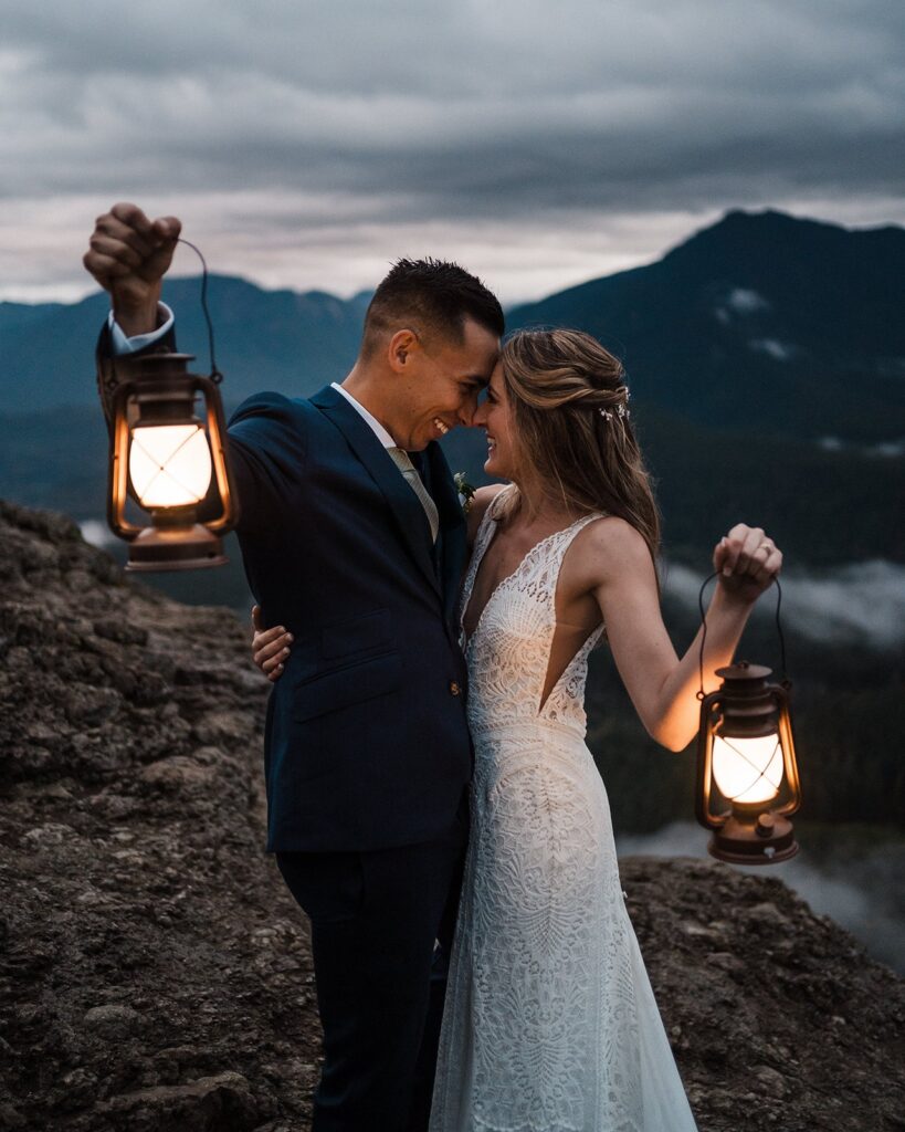 Bride and groom hold lanterns during blue hour at their Snoqualmie elopement in the mountains