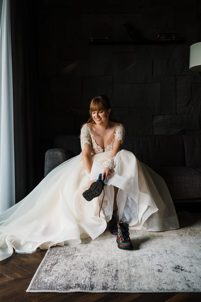 Bride putting on elopement hiking boots before her elopement in Iceland