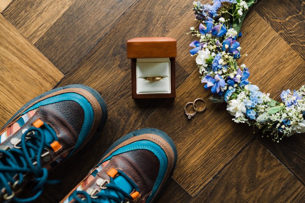 Wedding band in brown leather box with elopement hiking boots and flower crown