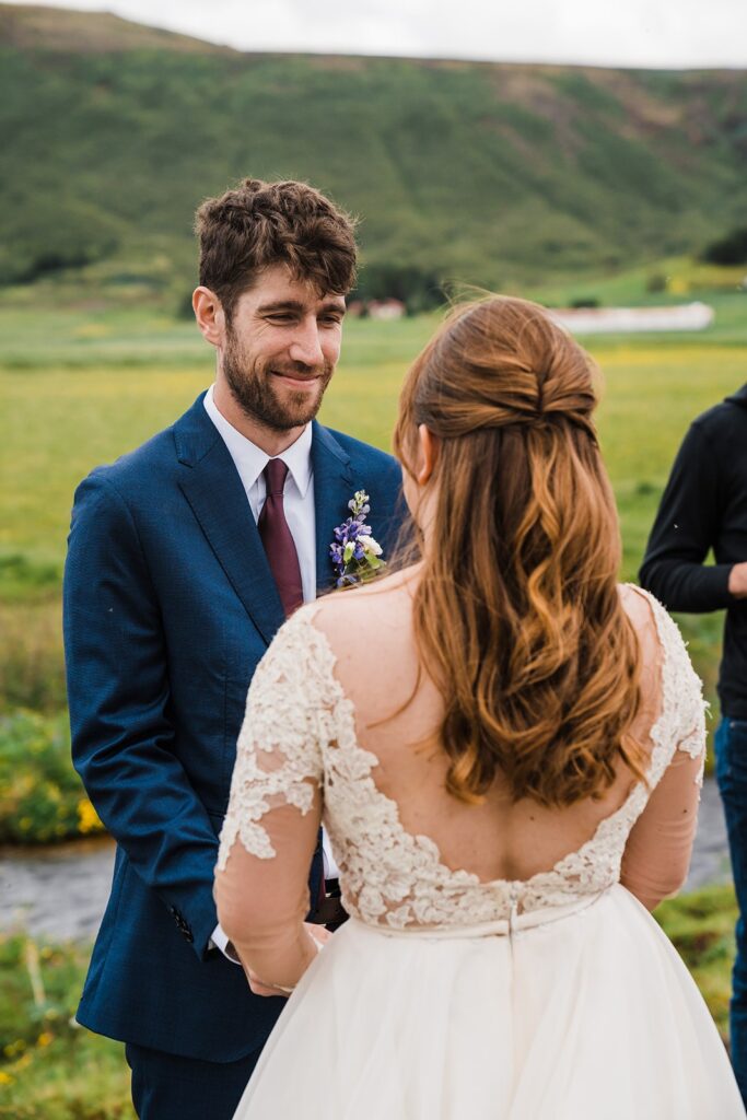Bride and groom hold hands during their Iceland elopement ceremony with family