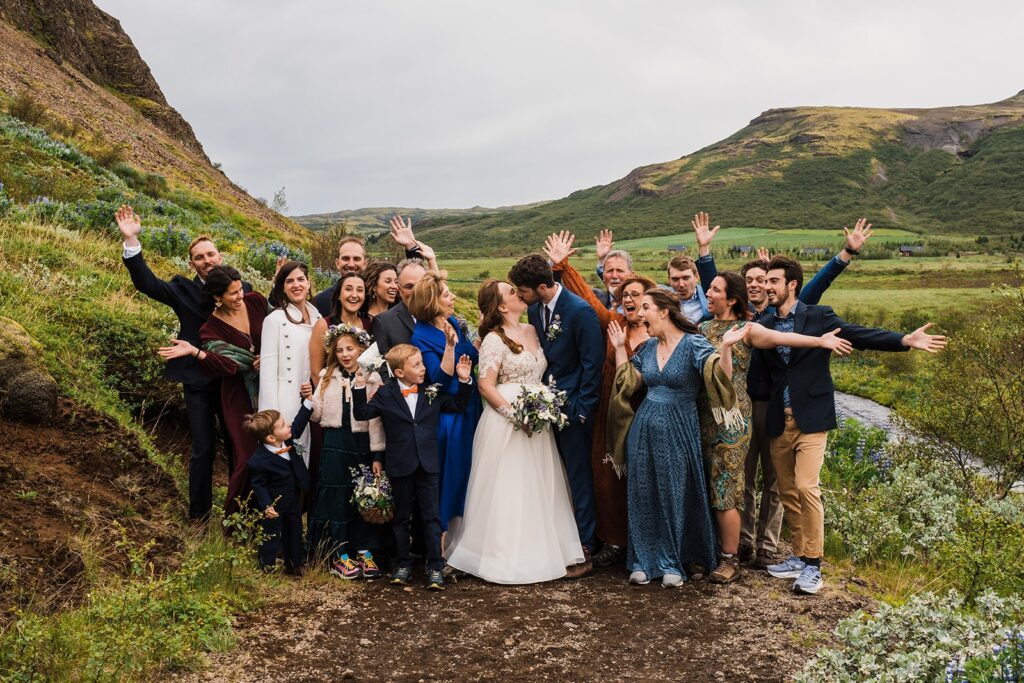 Wedding guests cheer while bride and groom kiss after their Iceland elopement ceremony
