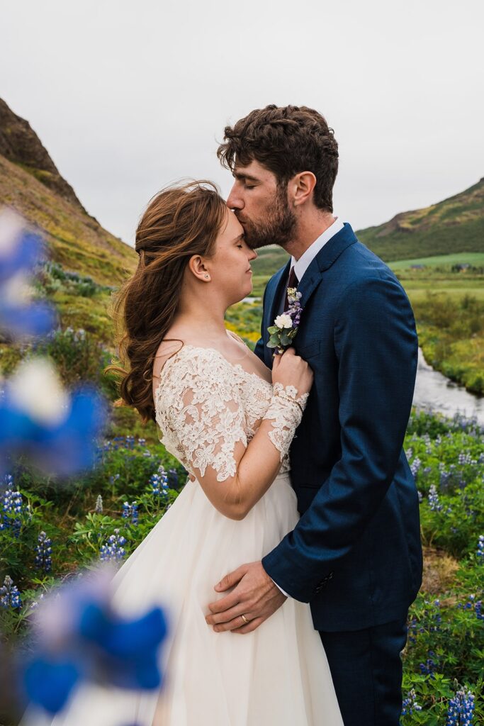 Groom kisses bride on the forehead after their outdoor elopement ceremony in Iceland
