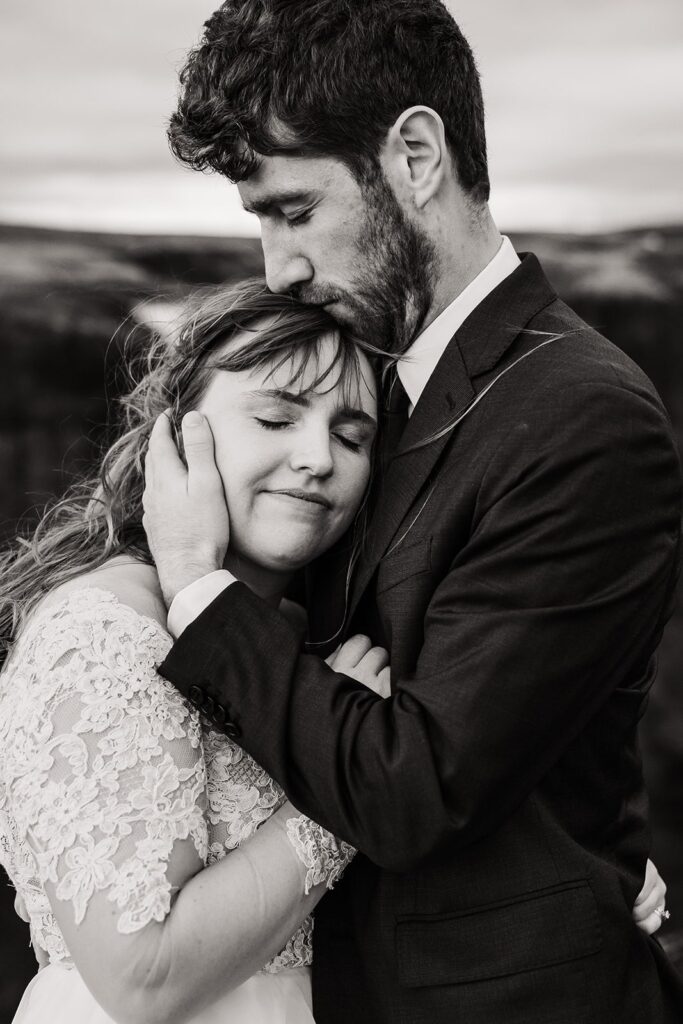 Groom kisses bride on the head during their elopement photos in Iceland