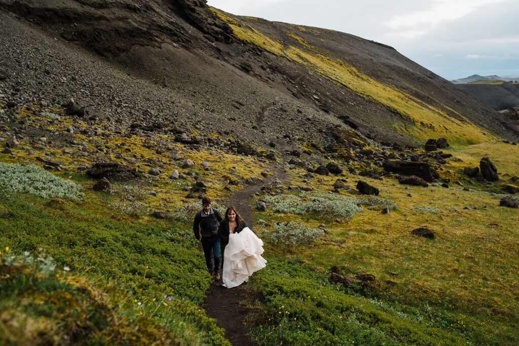 Bride and groom hike along a mountain trail during their elopement in Iceland