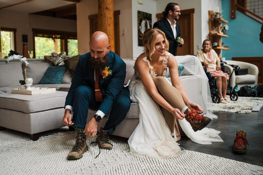 Bride and groom lace up hiking boots at their micro wedding venue in Washington