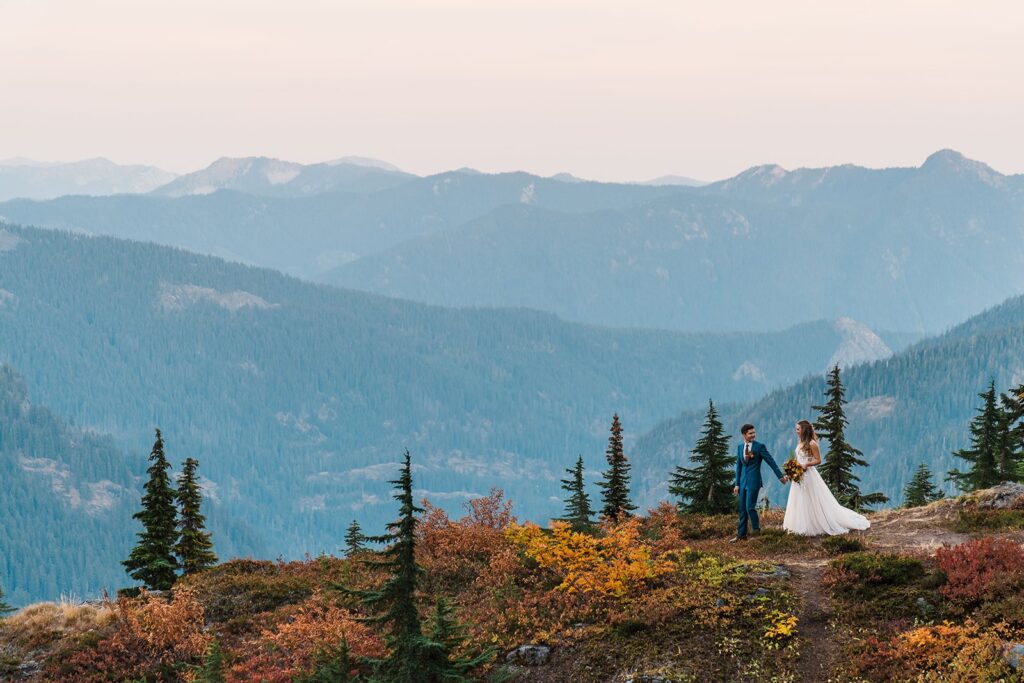 Bride and groom hold hands while walking around a mountain trail during their Snoqualmie Pass elopement
