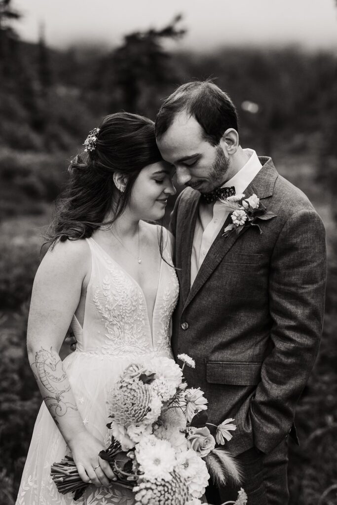 Bride and groom hug during their rainy wedding at Barclay Lake