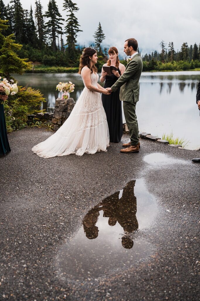 Bride and groom hold hands during North Cascades rainy wedding ceremony 