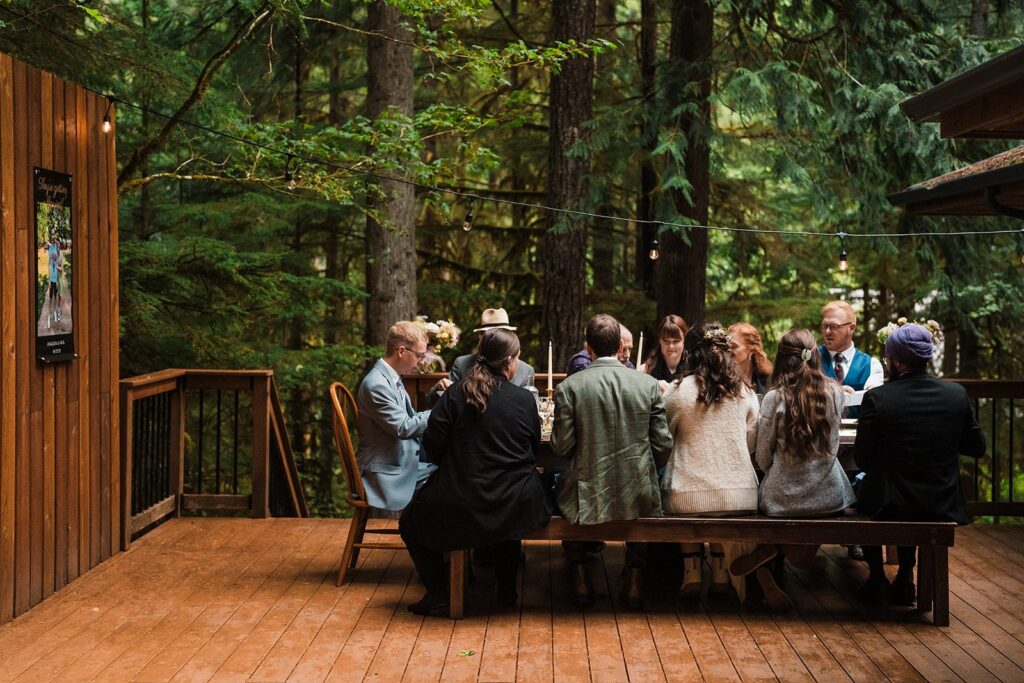 Bride and groom share a meal with guests at their North Cascades wedding reception in the rain