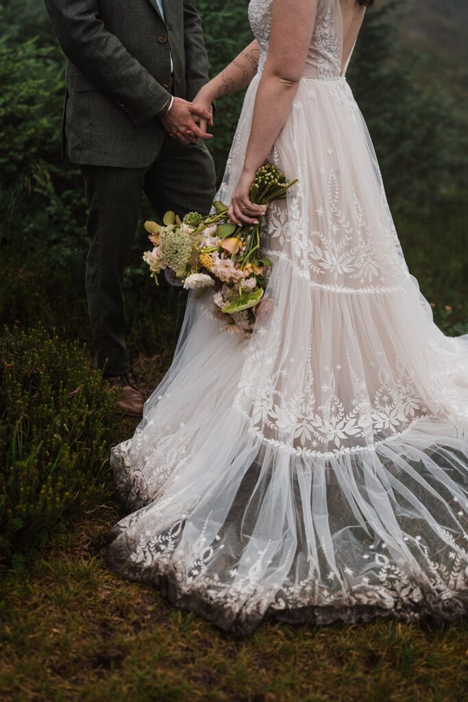 Bride and groom hold hands during their North Cascades rainy wedding