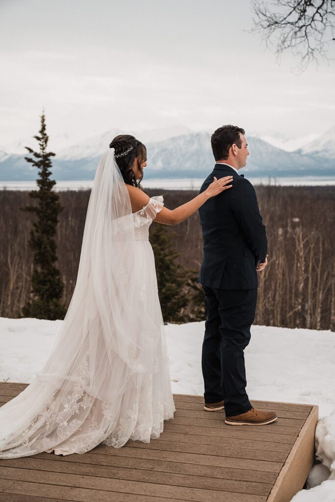 Bride taps groom on the shoulder for their first look before their Alaska glacier elopement