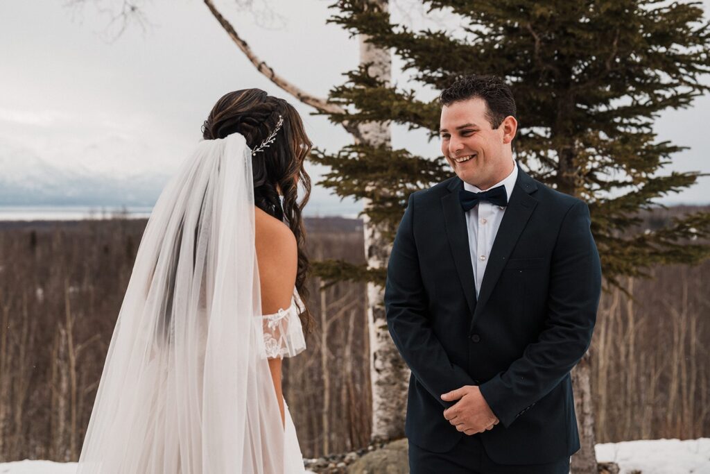 Groom smiles as he turns around for his elopement first look in Alaska