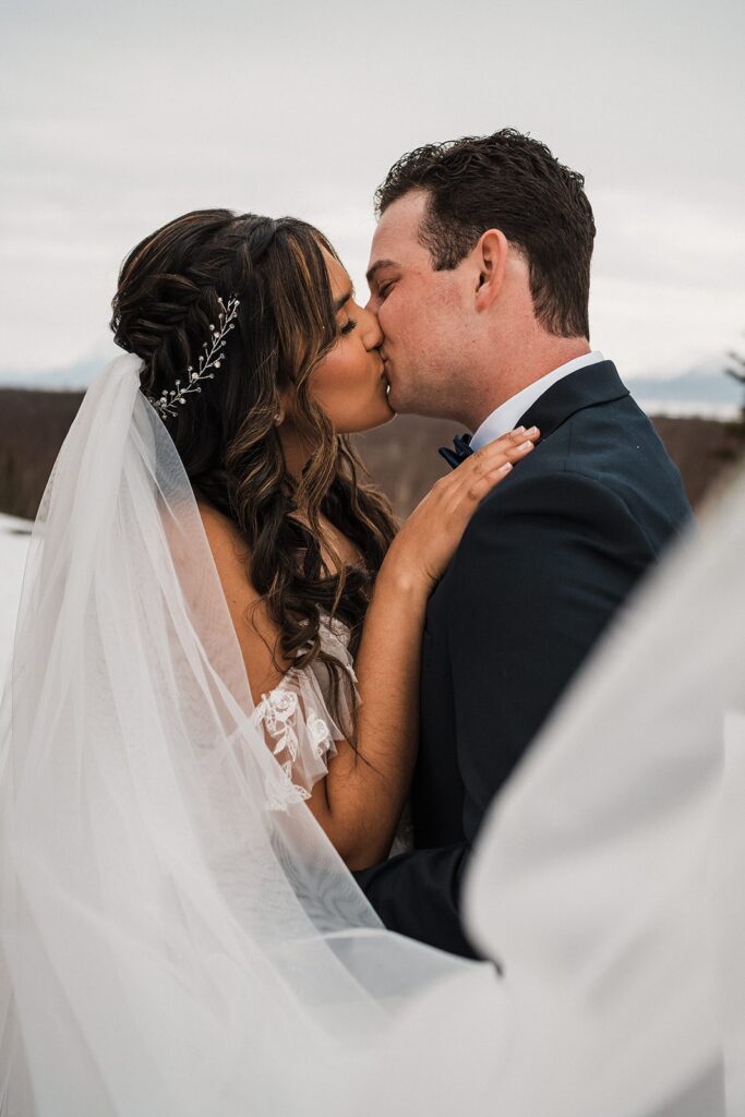 Bride and groom kiss during their first look in Alaska