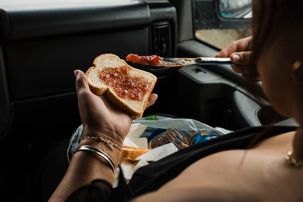 Bride assembles a PB&J in the car while riding to her Alaska glacier elopement