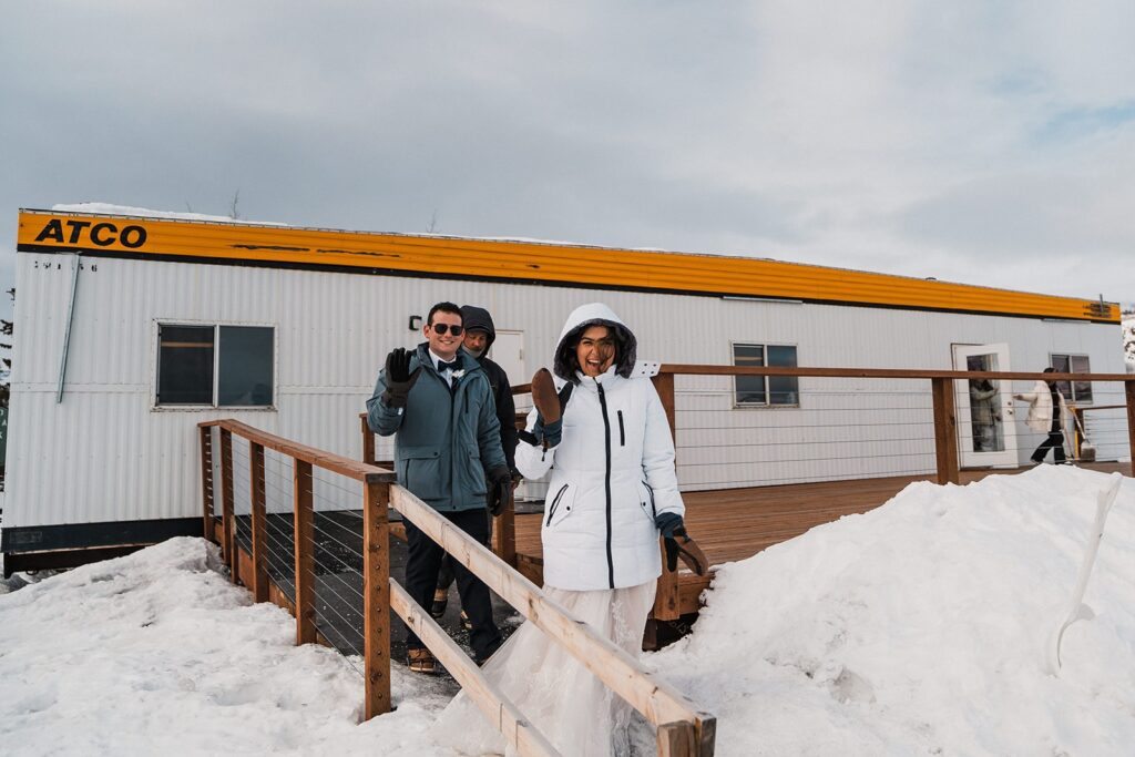 Bride and groom wave as they get ready to go on their glacier elopement adventure in Alaska