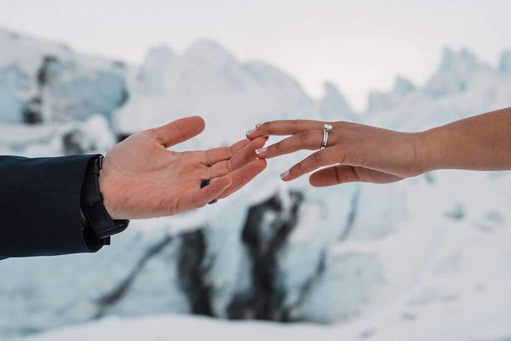 Bride and groom touch fingers during their Alaska glacier elopement 