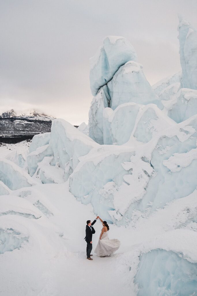 Bride and groom dance on a glacier in Alaska during their adventure elopement