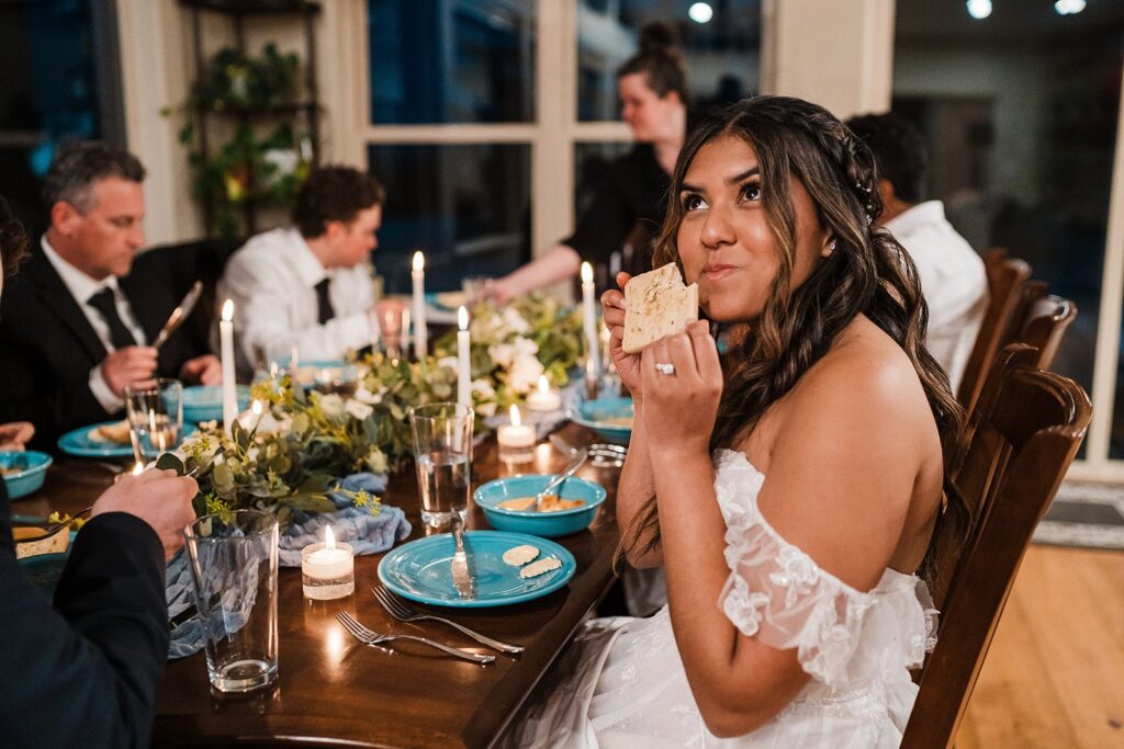 Bride and groom eat dinner with their guests at their private meal at their elopement cabin