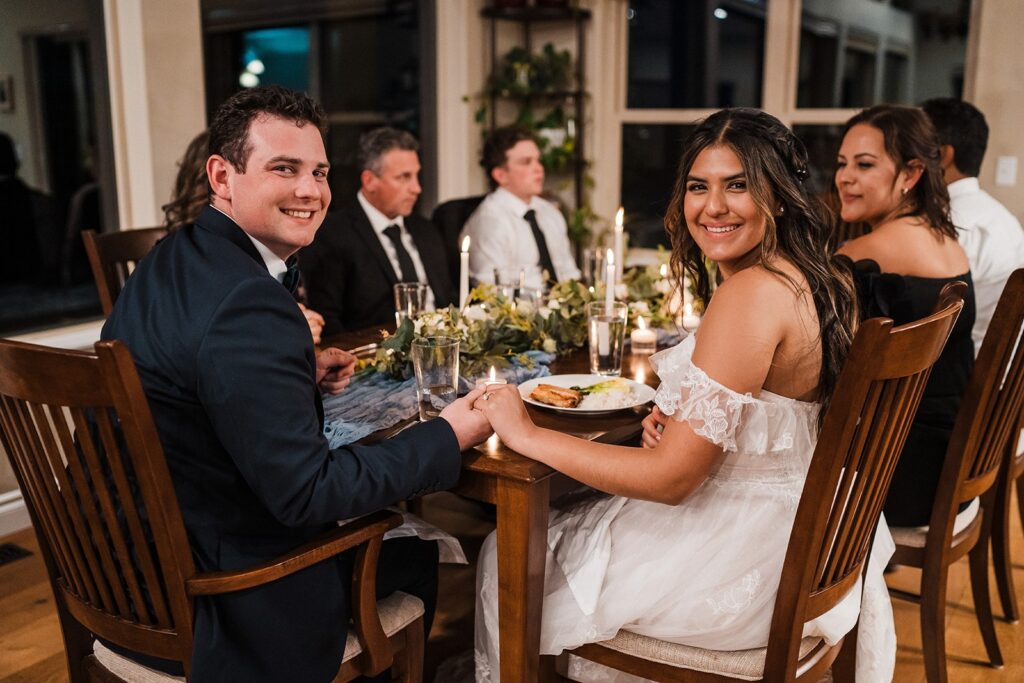 Bride and groom eat dinner with their guests at their private meal at their elopement cabin