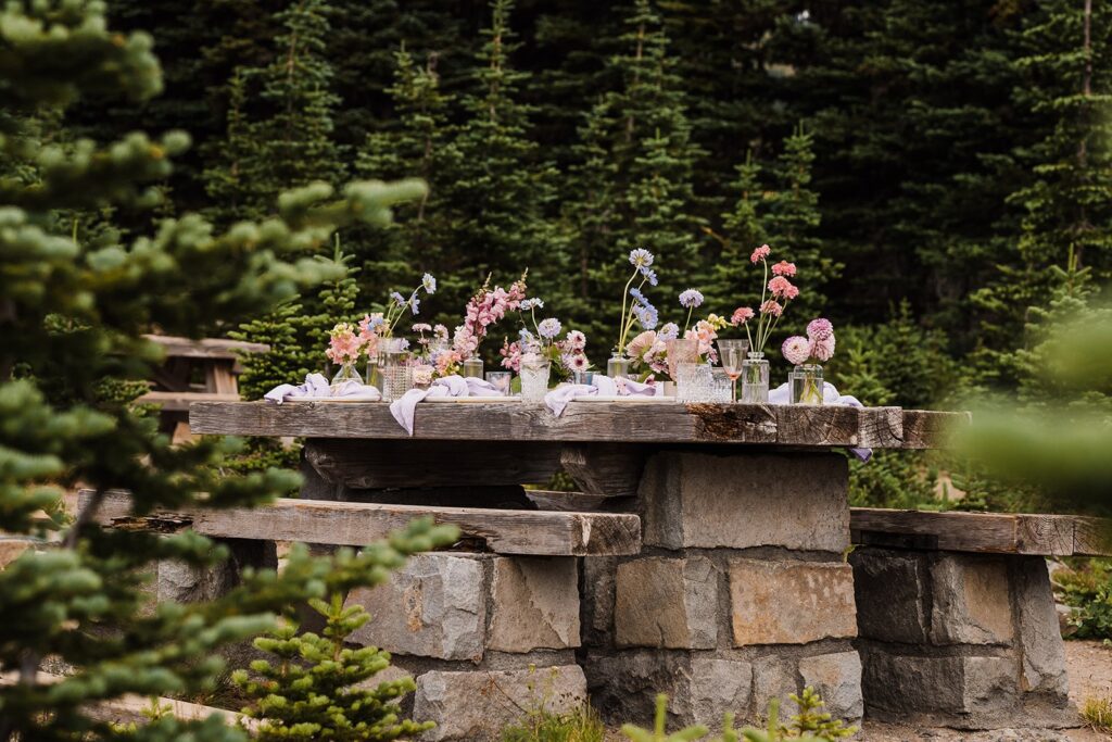 Pastel flowers line a day use area picnic table being used as a micro wedding venue