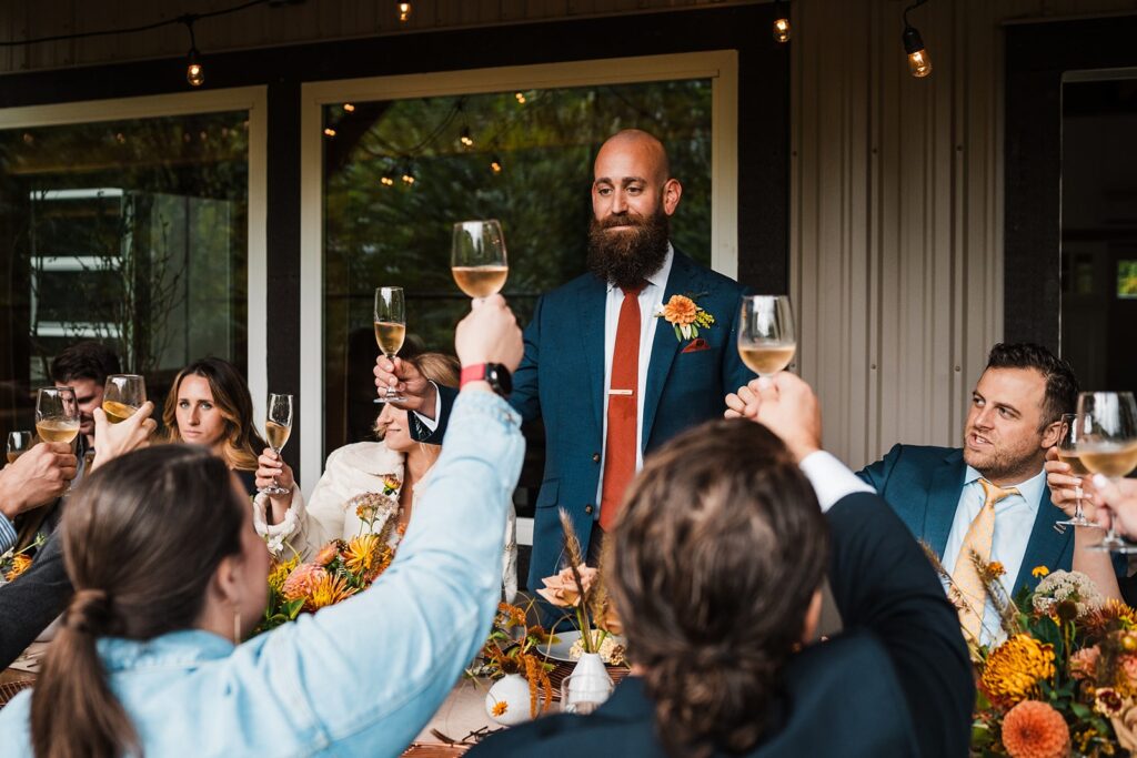 Groom gives a toasts with guests at their North Cascades, Washington micro wedding venue 